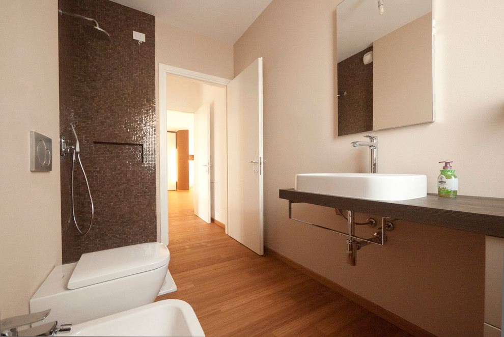 Inspiration pour une salle de bain principale minimaliste de taille moyenne avec un plan vasque, un plan de toilette en bois, une douche d'angle, WC séparés, un carrelage marron, mosaïque, un mur beige et parquet en bambou.