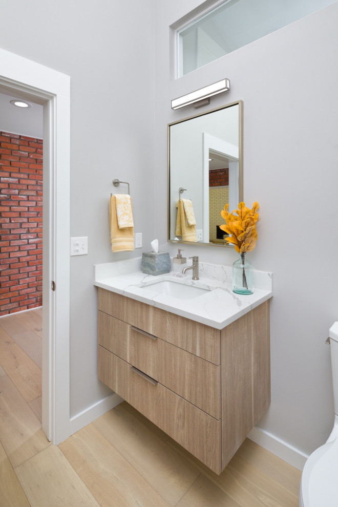 Photo of a modern bathroom in Denver with flat-panel cabinets, engineered stone worktops, a single sink, grey walls, a built-in sink and white worktops.