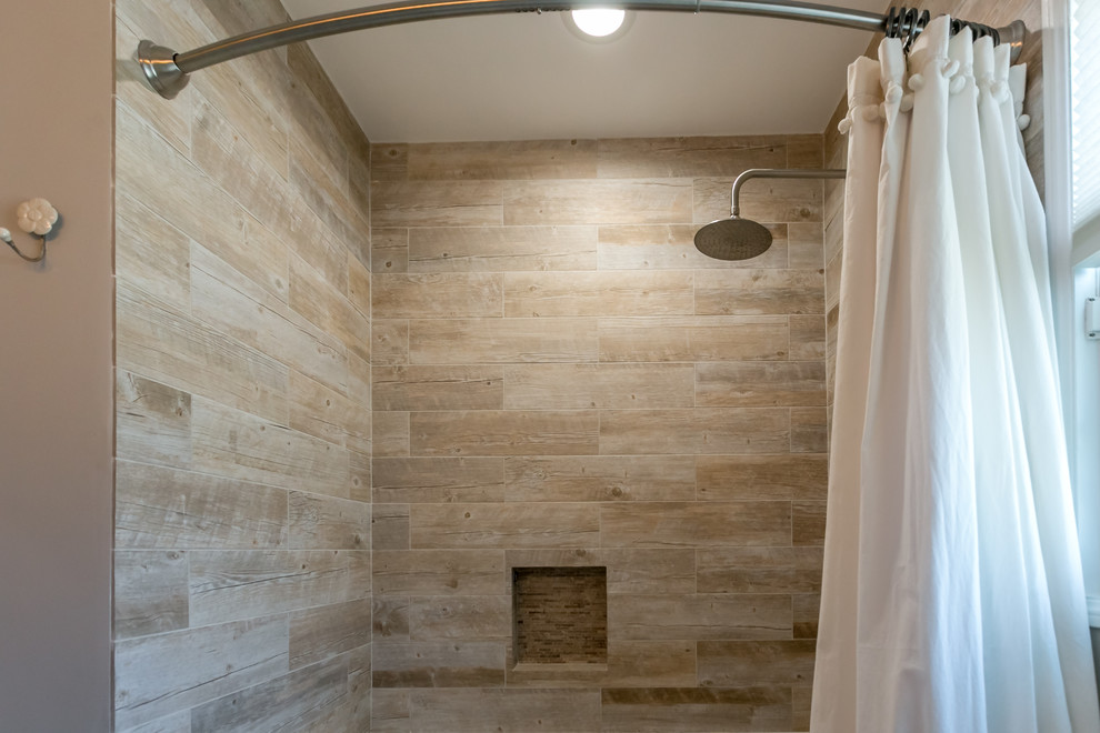 Cette image montre une salle d'eau marine en bois brun de taille moyenne avec un placard en trompe-l'oeil, une baignoire en alcôve, un combiné douche/baignoire, WC séparés, un carrelage marron, un carrelage gris, des carreaux de porcelaine, un mur gris, un lavabo encastré et un plan de toilette en quartz.