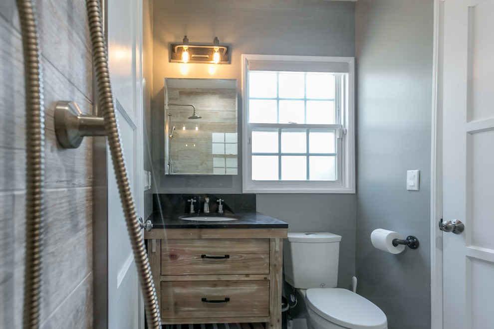 Exemple d'une salle de bain bord de mer en bois brun de taille moyenne avec un placard en trompe-l'oeil, WC séparés, un carrelage marron, un carrelage gris, des carreaux de porcelaine, un mur gris, un lavabo encastré et un plan de toilette en quartz.