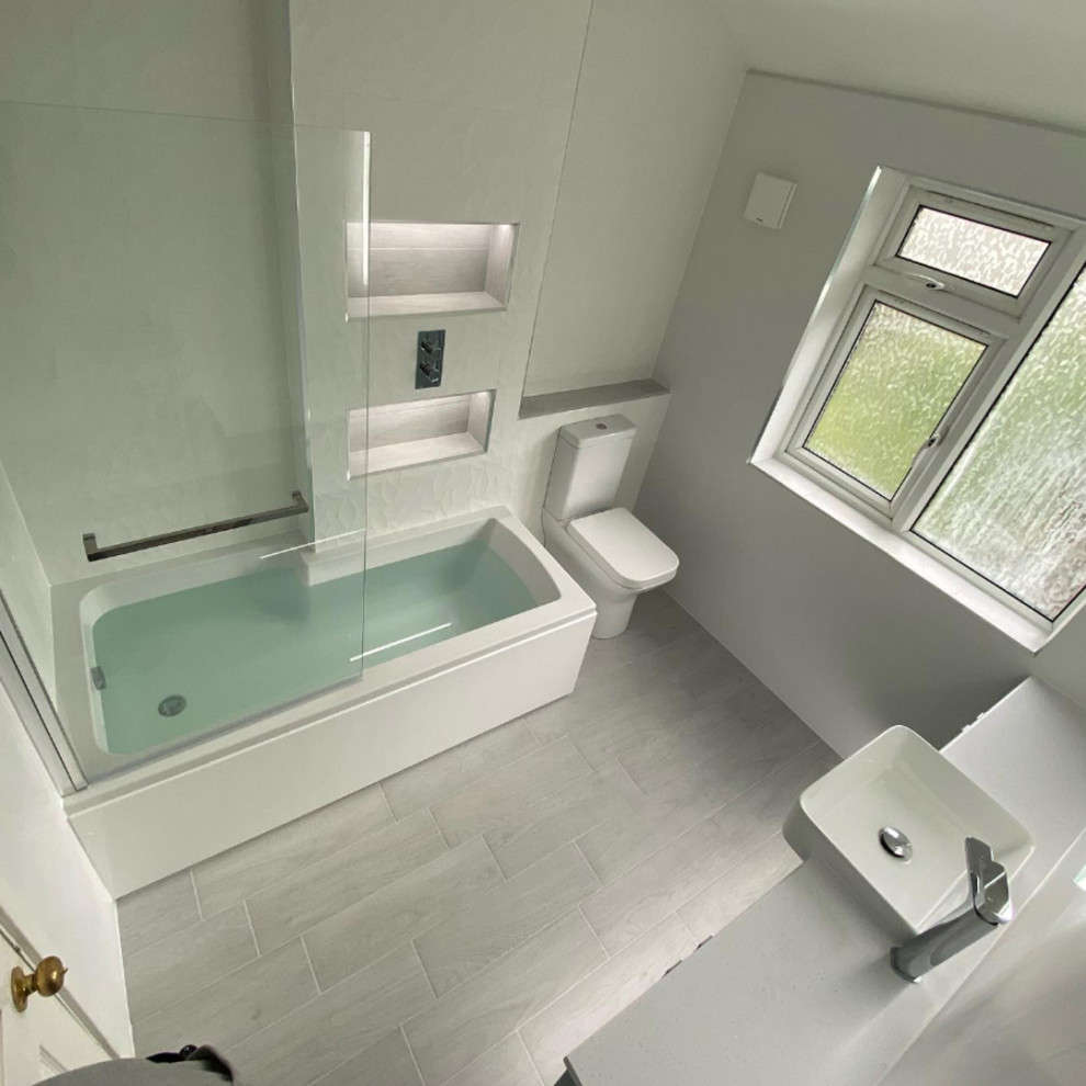 Inspiration för ett mellanstort funkis badrum för barn, med en dusch/badkar-kombination, vit kakel, porslinskakel, vita väggar, klinkergolv i porslin och vitt golv