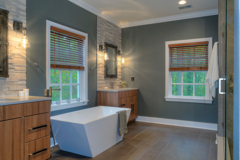 На фото: главная ванная комната в современном стиле с врезной раковиной, плоскими фасадами, светлыми деревянными фасадами, отдельно стоящей ванной, угловым душем и синими стенами