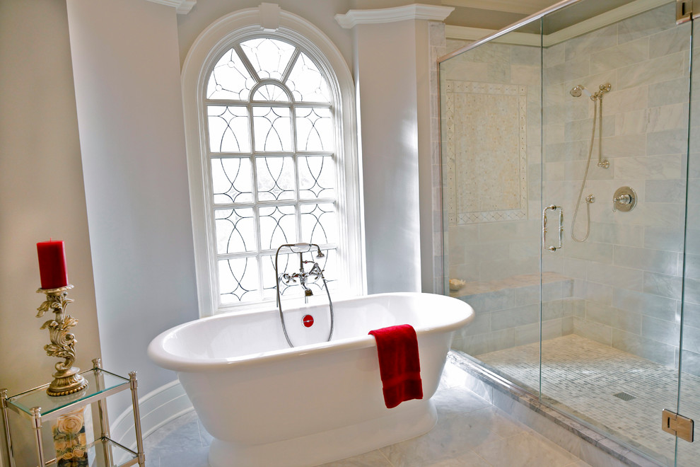 Inredning av ett klassiskt stort en-suite badrum, med ett undermonterad handfat, luckor med upphöjd panel, vita skåp, granitbänkskiva, ett fristående badkar, en dubbeldusch, grå kakel, stenkakel, grå väggar och marmorgolv