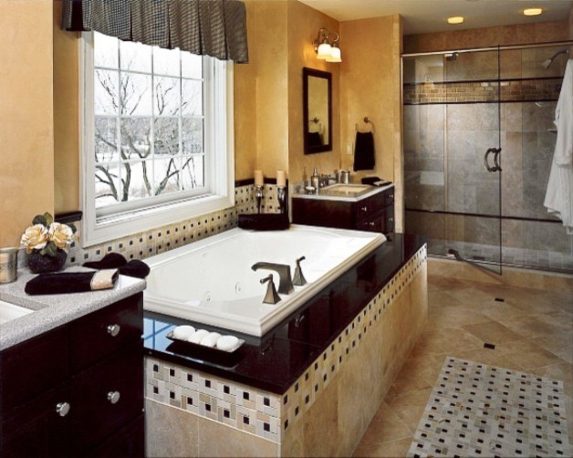 Modelo de cuarto de baño principal tradicional con lavabo bajoencimera, armarios con paneles lisos, puertas de armario de madera en tonos medios, encimera de granito, bañera encastrada, ducha doble, sanitario de dos piezas y paredes amarillas