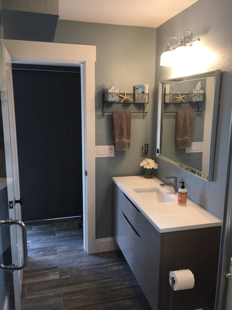Idéer för att renovera ett litet vintage badrum med dusch, med släta luckor, grå skåp, en dusch i en alkov, en toalettstol med separat cisternkåpa, blå kakel, grå kakel, vit kakel, cementkakel, blå väggar, ljust trägolv, ett undermonterad handfat och bänkskiva i akrylsten
