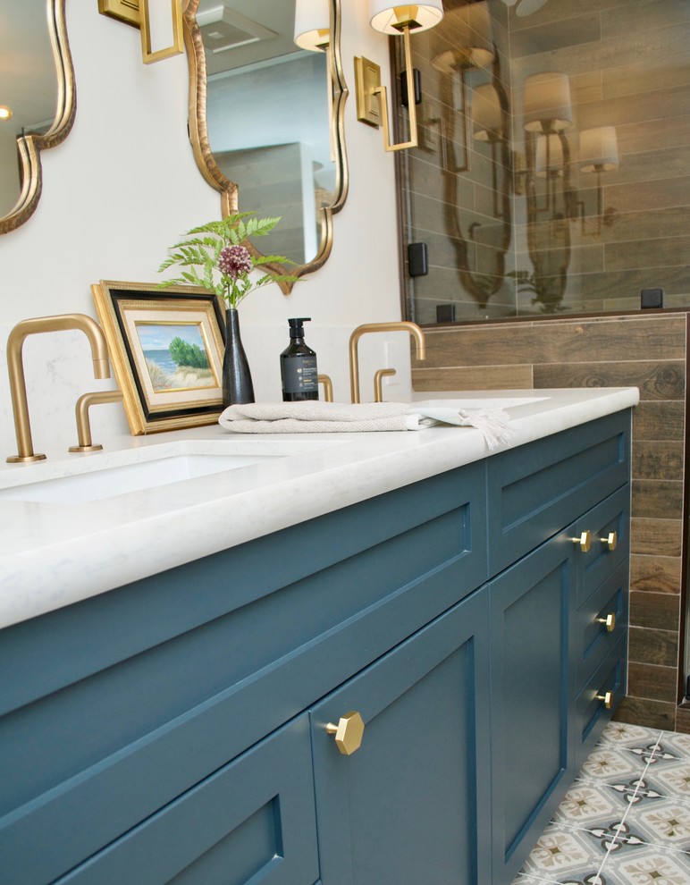 Exemple d'une petite salle de bain principale avec des portes de placard bleues, une baignoire sur pieds, un carrelage marron, un mur marron, un sol en bois brun, un plan de toilette en quartz, une cabine de douche à porte battante et un plan de toilette blanc.