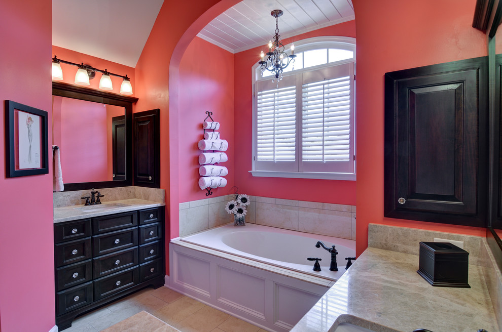 Imagen de cuarto de baño infantil contemporáneo de tamaño medio con armarios tipo mueble, puertas de armario negras, bañera encastrada, baldosas y/o azulejos beige, paredes rosas y lavabo bajoencimera