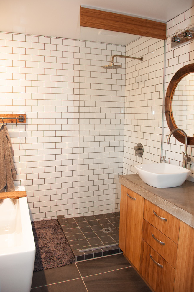 Aménagement d'une salle de bain industrielle en bois brun de taille moyenne avec une vasque, un placard à porte plane, un plan de toilette en béton, une baignoire indépendante, une douche ouverte, WC séparés, un carrelage blanc, des carreaux de céramique et un mur blanc.