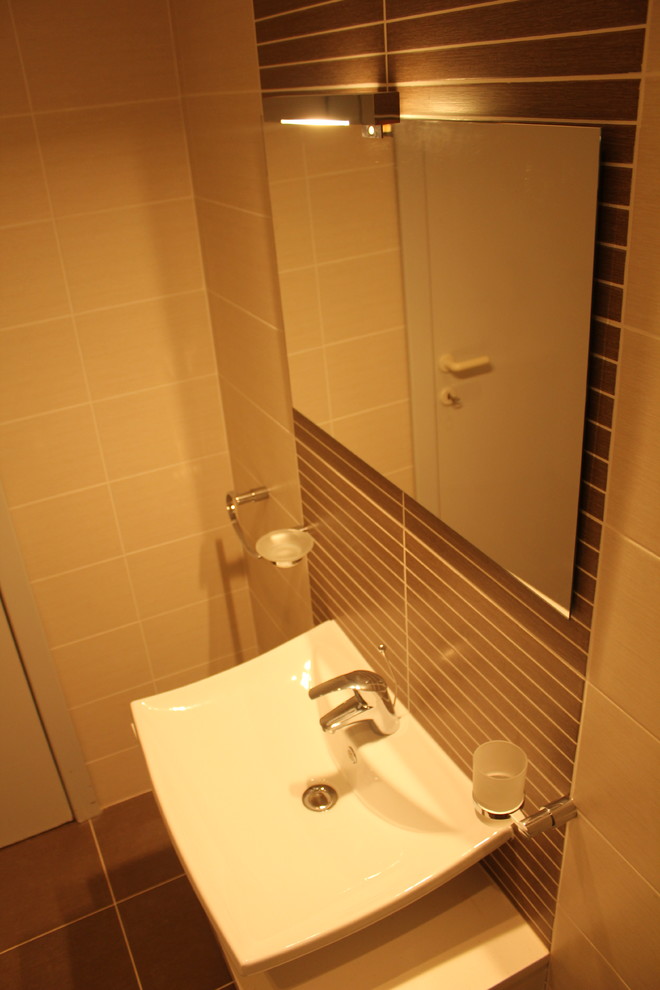 Inspiration för ett mellanstort funkis en-suite badrum, med ett konsol handfat, släta luckor, vita skåp, laminatbänkskiva, ett hörnbadkar, en dusch/badkar-kombination, en vägghängd toalettstol, beige kakel, keramikplattor och klinkergolv i keramik