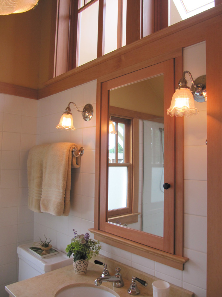 Идея дизайна: маленькая ванная комната в стиле кантри с врезной раковиной, душем в нише, раздельным унитазом, фасадами с утопленной филенкой, фасадами цвета дерева среднего тона, белой плиткой, керамической плиткой, оранжевыми стенами, полом из известняка, душевой кабиной и столешницей из известняка для на участке и в саду