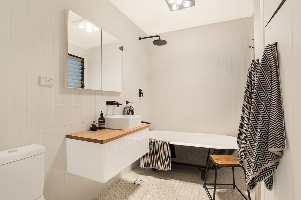 Inspiration för ett vintage badrum, med släta luckor, vita skåp, ett badkar med tassar, en dusch/badkar-kombination, en toalettstol med separat cisternkåpa och ett fristående handfat