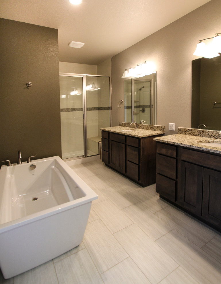 This is an example of a medium sized classic ensuite bathroom in Denver with a submerged sink, shaker cabinets, dark wood cabinets, granite worktops, a freestanding bath, an alcove shower, a one-piece toilet, white tiles, ceramic tiles, brown walls and porcelain flooring.