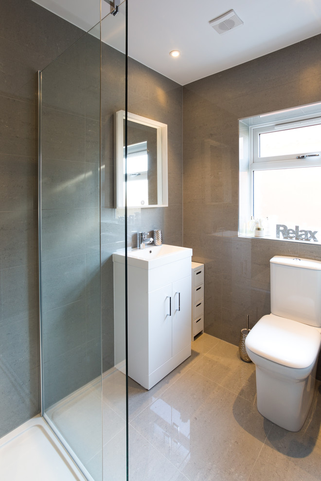 Design ideas for a small contemporary ensuite bathroom in Surrey with flat-panel cabinets, white cabinets, a walk-in shower, a one-piece toilet, brown tiles, brown walls and a wall-mounted sink.