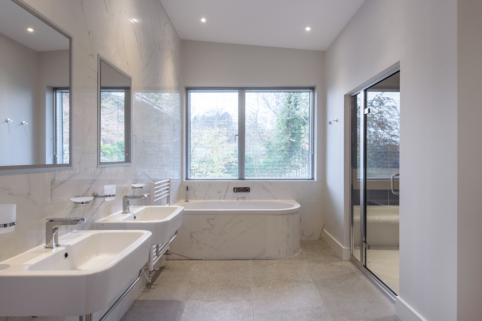 Стильный дизайн: ванная комната среднего размера в стиле модернизм с белыми фасадами, серой плиткой, мраморной плиткой, серыми стенами, подвесной раковиной и серым полом - последний тренд