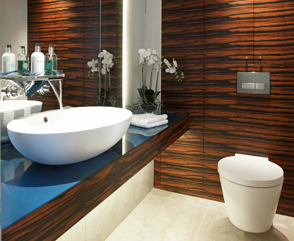 This is an example of a contemporary bathroom in Other with a console sink, a wall mounted toilet, wooden worktops, beige tiles and limestone flooring.