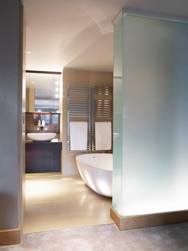 Large contemporary bathroom in Other with a freestanding bath, a vessel sink, dark wood cabinets, wooden worktops, beige tiles, stone tiles, beige walls and limestone flooring.