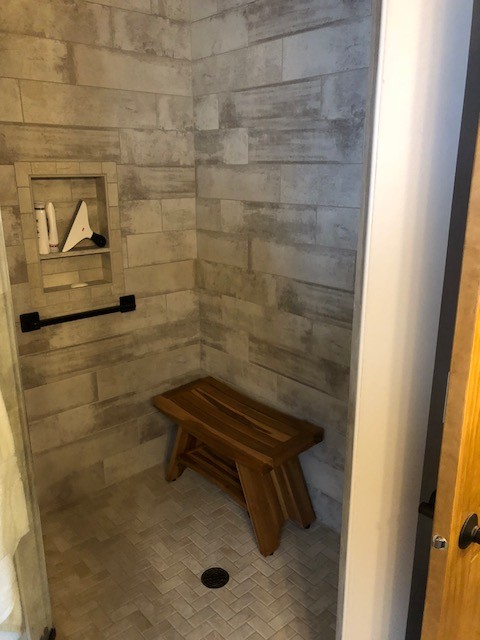 Immagine di una stanza da bagno con doccia stile rurale di medie dimensioni con doccia ad angolo, piastrelle grigie, piastrelle in gres porcellanato, pareti grigie, pavimento in gres porcellanato, pavimento grigio e porta doccia a battente