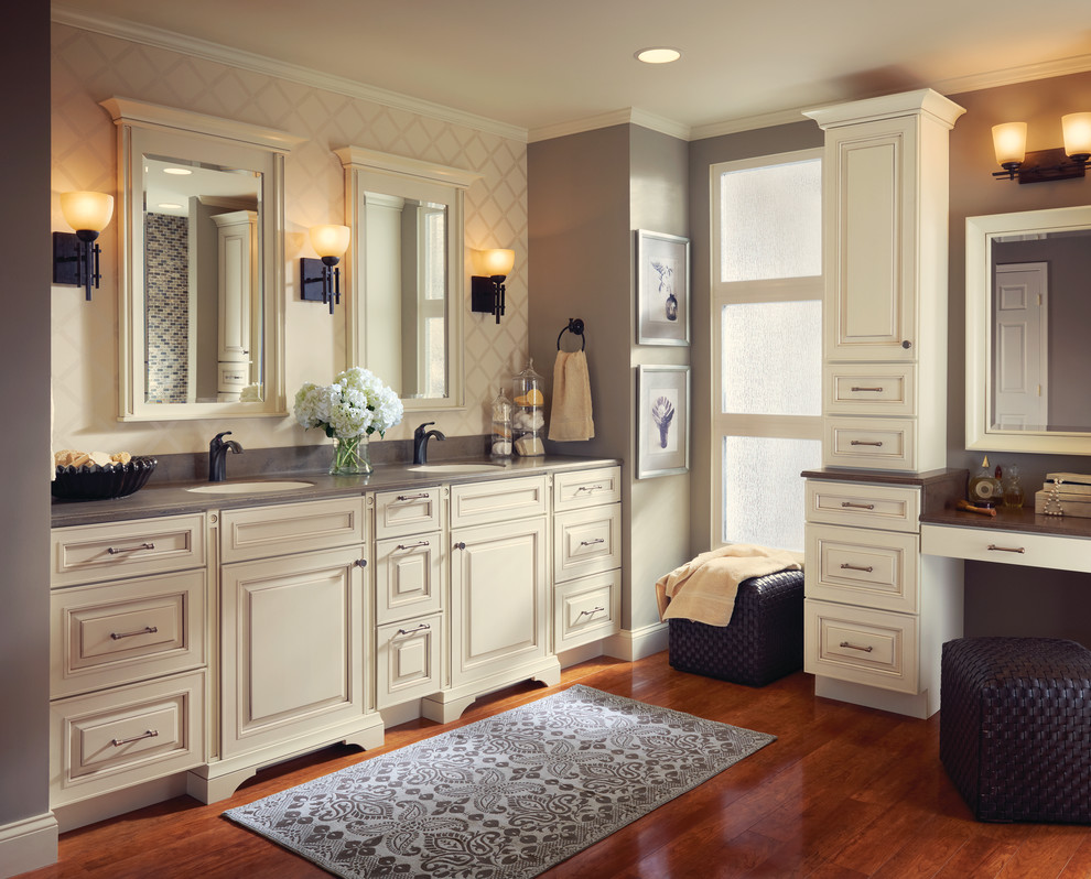 Elegant medium tone wood floor bathroom photo in Other with an undermount sink, raised-panel cabinets, white cabinets and solid surface countertops