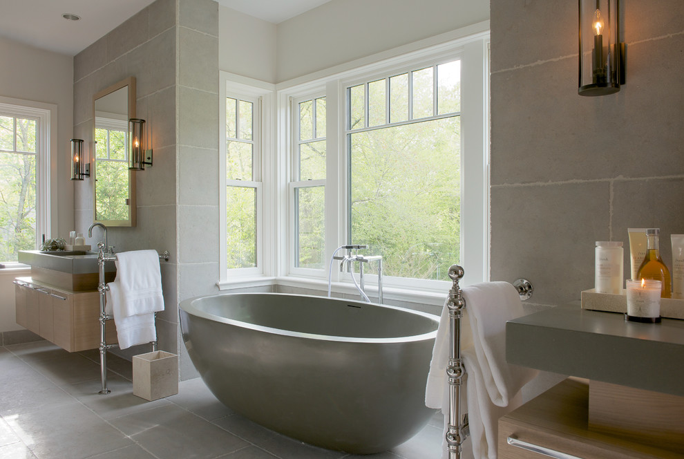 Exempel på ett mellanstort klassiskt en-suite badrum, med ett fristående badkar, släta luckor, skåp i ljust trä, grå väggar, betonggolv, ett undermonterad handfat och bänkskiva i akrylsten