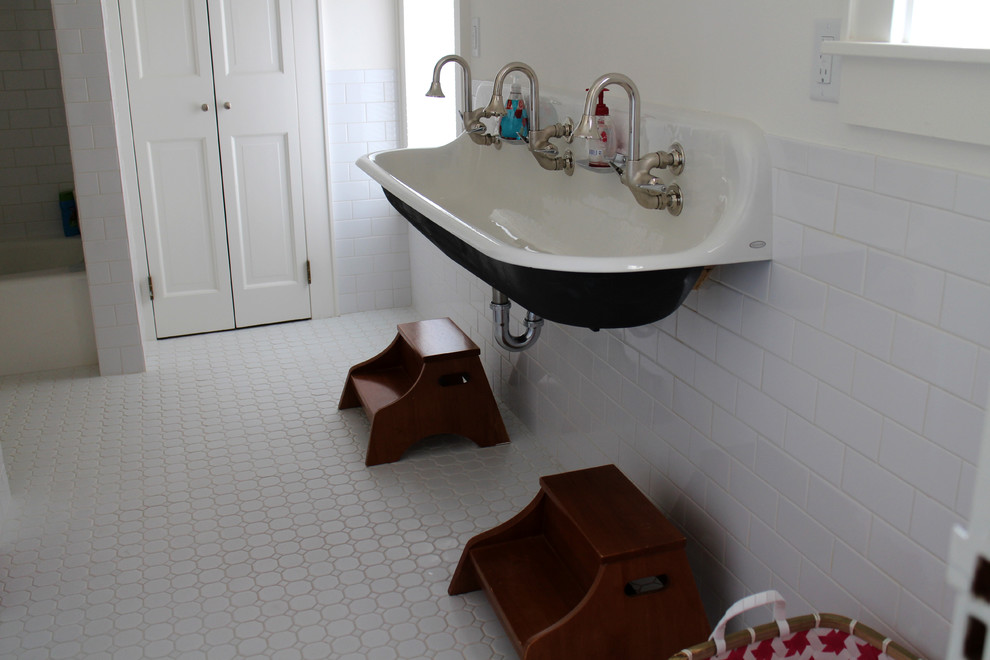 Cette image montre une grande salle de bain traditionnelle pour enfant avec une baignoire en alcôve, un combiné douche/baignoire, WC à poser, un carrelage blanc, un carrelage métro, un mur blanc et un sol en carrelage de terre cuite.