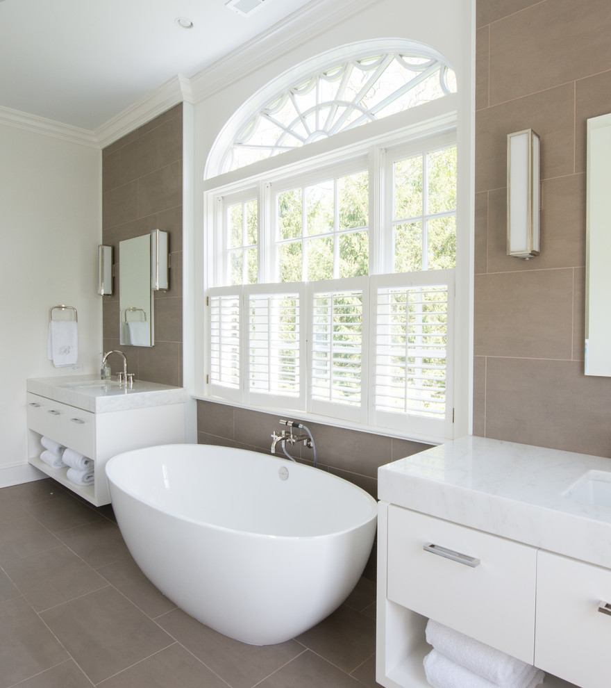 Exempel på ett stort klassiskt en-suite badrum, med släta luckor, vita skåp, ett fristående badkar, beige kakel, travertinkakel, beige väggar, travertin golv, ett undermonterad handfat och marmorbänkskiva