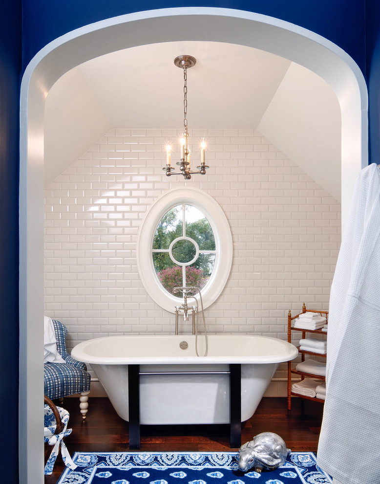 На фото: главная ванная комната среднего размера в классическом стиле с отдельно стоящей ванной, белыми стенами, темным паркетным полом, коричневым полом, белой плиткой и плиткой кабанчик