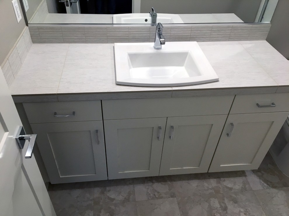 Shower room bathroom in Portland with shaker cabinets, white cabinets, grey tiles, ceramic tiles, grey walls, lino flooring, a built-in sink, tiled worktops, grey floors and grey worktops.