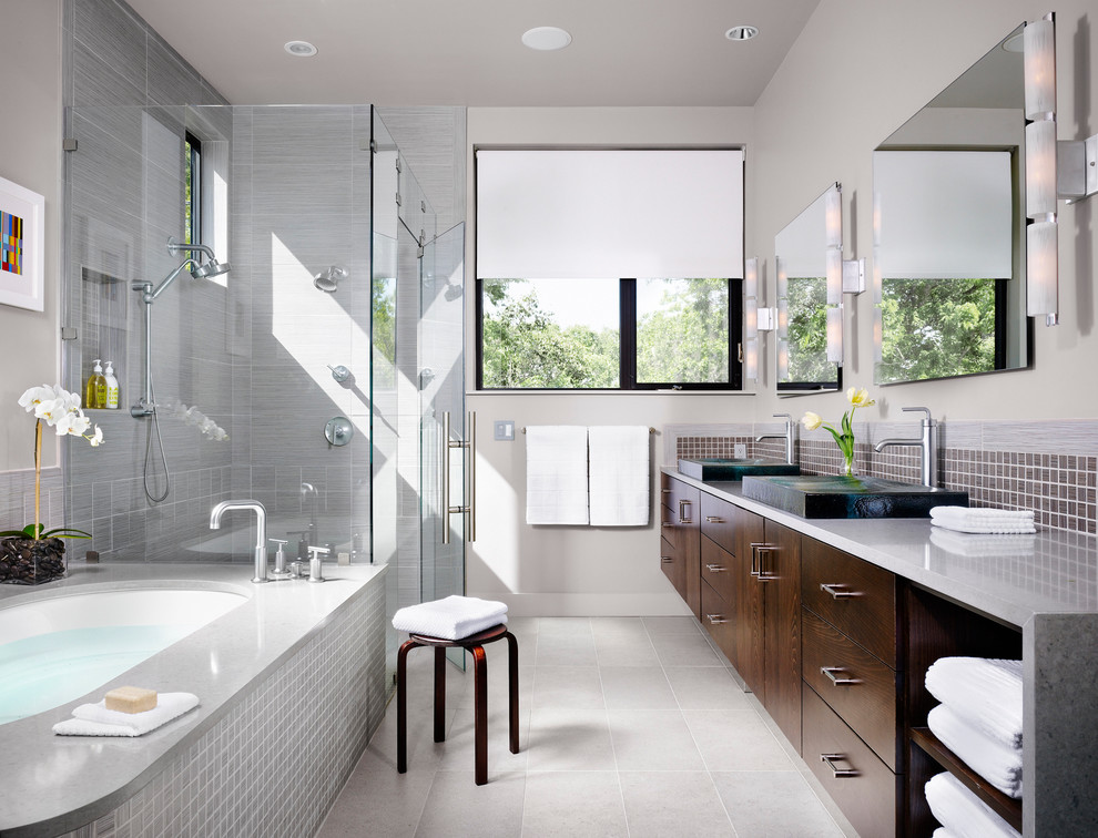 Corner shower - mid-sized contemporary master gray tile and mosaic tile ceramic tile corner shower idea in Austin with dark wood cabinets, an undermount tub, flat-panel cabinets, gray walls, a trough sink, quartz countertops and gray countertops