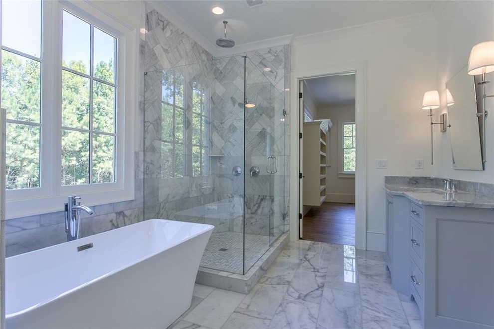 Example of a large transitional master gray tile and marble tile marble floor and gray floor bathroom design in Atlanta with recessed-panel cabinets, gray cabinets, a two-piece toilet, white walls, an undermount sink, marble countertops, a hinged shower door and gray countertops