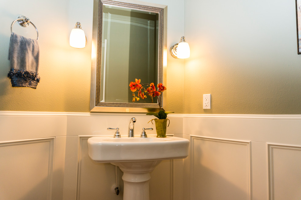 Ejemplo de cuarto de baño clásico pequeño con aseo y ducha, lavabo con pedestal, paredes beige y suelo de madera en tonos medios