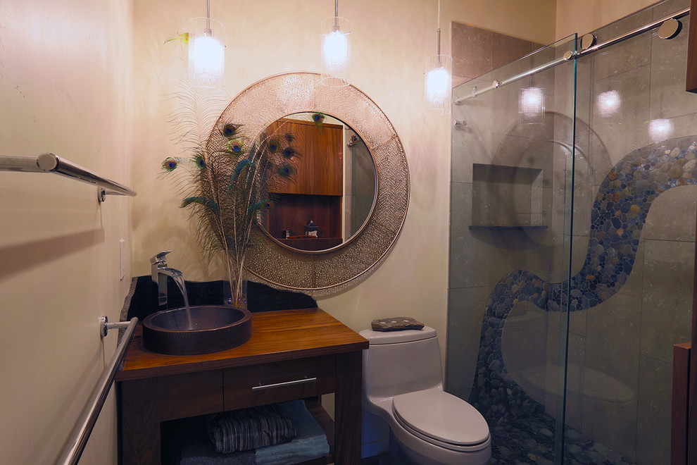 Mittelgroßes Rustikales Duschbad mit verzierten Schränken, dunklen Holzschränken, Duschnische, Toilette mit Aufsatzspülkasten, schwarzen Fliesen, grauen Fliesen, Kieselfliesen, beiger Wandfarbe, Aufsatzwaschbecken und Waschtisch aus Holz in Sacramento