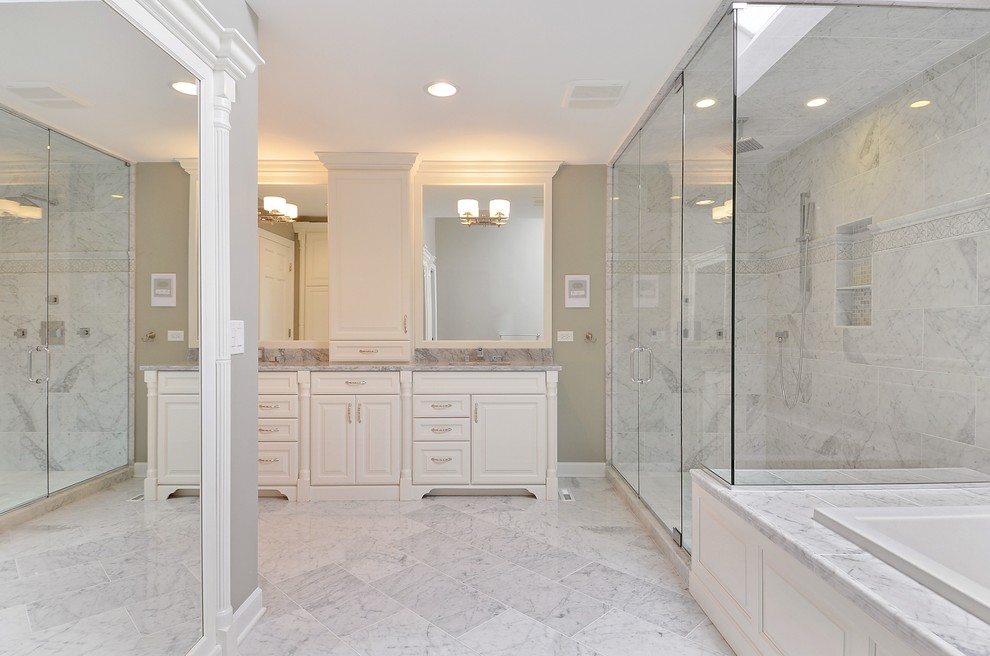 Inspiration for an expansive traditional ensuite bathroom in Chicago with recessed-panel cabinets, white cabinets, a corner bath, an alcove shower, a one-piece toilet, glass tiles, grey walls, ceramic flooring, a console sink and marble worktops.
