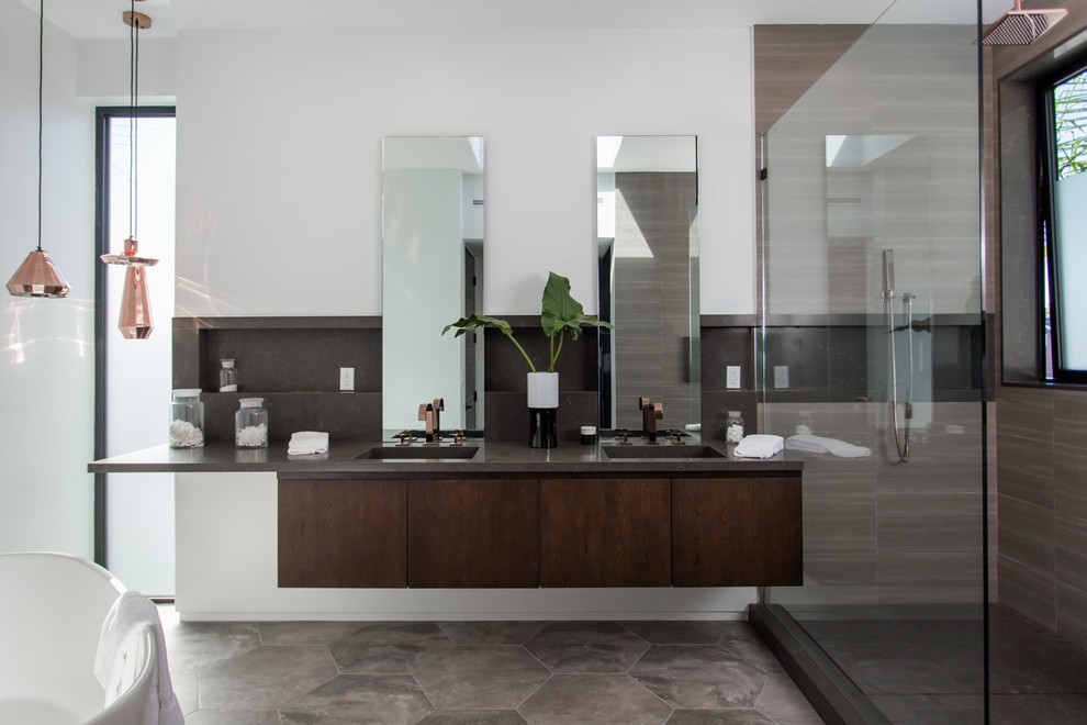 ロサンゼルスにあるコンテンポラリースタイルのおしゃれな浴室 (フラットパネル扉のキャビネット、濃色木目調キャビネット、置き型浴槽、茶色いタイル、白い壁、一体型シンク、グレーの床、オープンシャワー、ブラウンの洗面カウンター) の写真