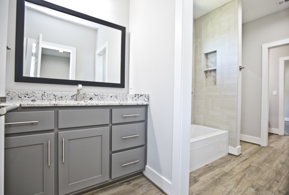 Diseño de cuarto de baño actual con encimera de granito y encimeras blancas