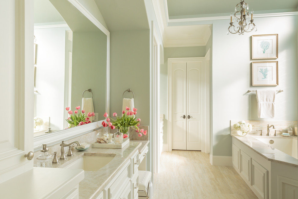 Réalisation d'une grande salle de bain principale méditerranéenne avec un lavabo encastré, un placard avec porte à panneau surélevé, des portes de placard blanches, un plan de toilette en quartz, un carrelage beige, mosaïque, un mur bleu, un sol en travertin et une baignoire encastrée.