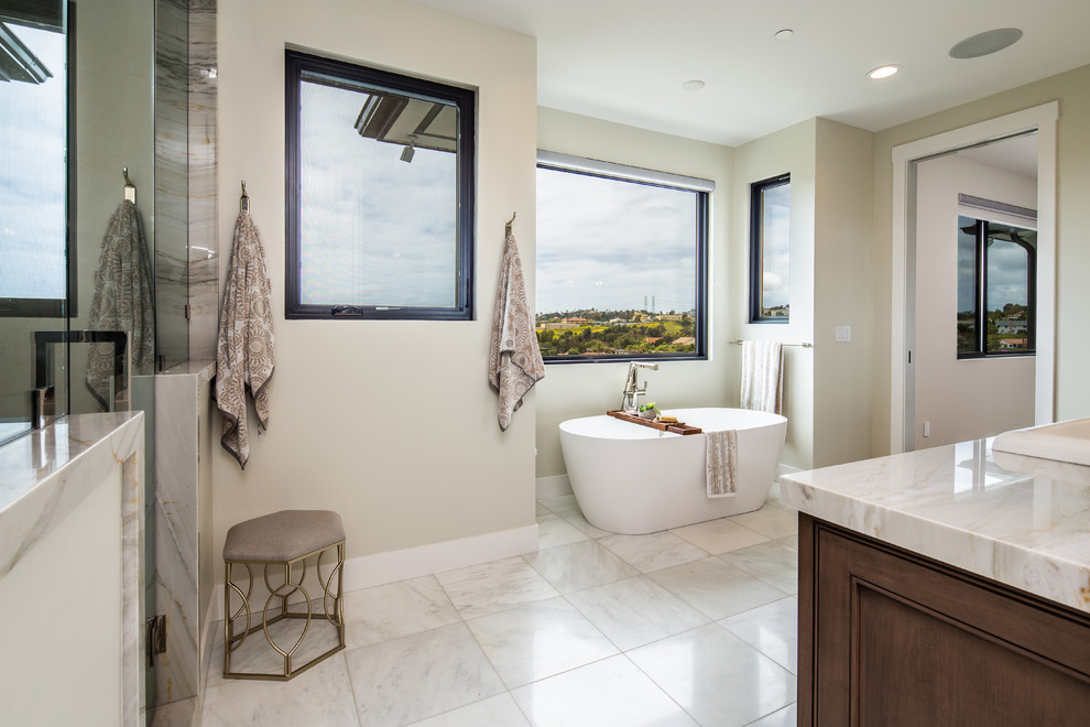 Photo of a large coastal family bathroom in San Diego with beaded cabinets, beige tiles, porcelain tiles, blue cabinets, an alcove bath, a shower/bath combination, a two-piece toilet, grey walls, porcelain flooring, a submerged sink, engineered stone worktops, beige floors, a shower curtain and white worktops.