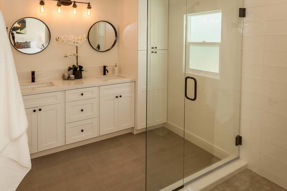 Foto på ett mellanstort lantligt vit badrum med dusch, med skåp i shakerstil, vita skåp, en dusch i en alkov, vit kakel, porslinskakel, vita väggar, klinkergolv i keramik, ett undermonterad handfat, bänkskiva i kvarts, grått golv och dusch med gångjärnsdörr