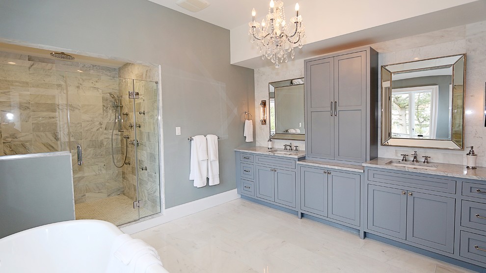 Idéer för att renovera ett mellanstort vintage grå grått en-suite badrum, med släta luckor, grå skåp, ett fristående badkar, en dubbeldusch, en toalettstol med separat cisternkåpa, grå kakel, porslinskakel, grå väggar, klinkergolv i porslin, ett undermonterad handfat, marmorbänkskiva, grått golv och dusch med gångjärnsdörr