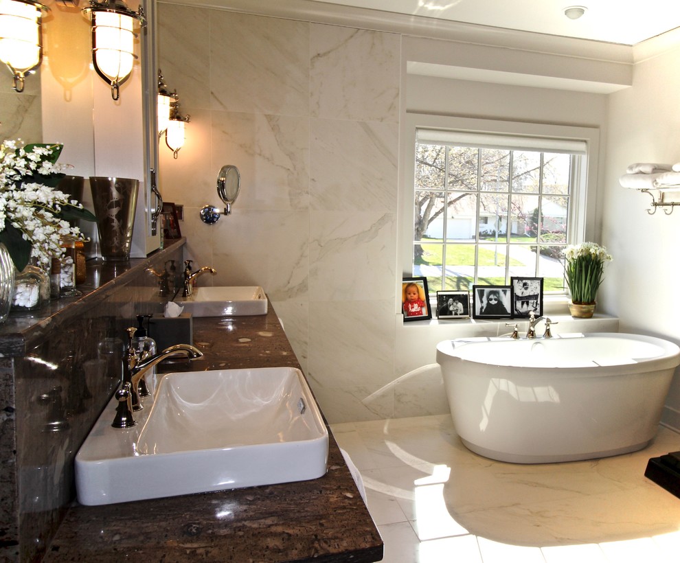 Ejemplo de cuarto de baño principal tradicional renovado de tamaño medio con bañera exenta, baldosas y/o azulejos multicolor, losas de piedra, paredes beige, lavabo encastrado, encimera de granito y suelo blanco