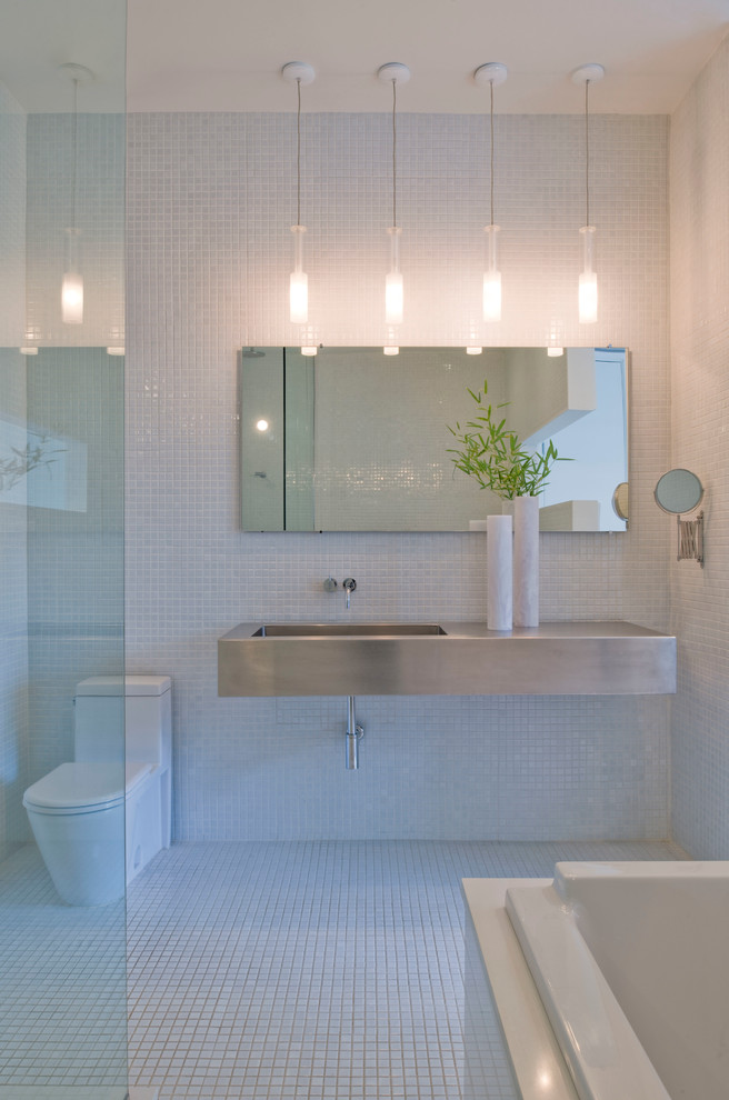 На фото: ванная комната в стиле модернизм с подвесной раковиной, белой плиткой, плиткой мозаикой и полом из мозаичной плитки с