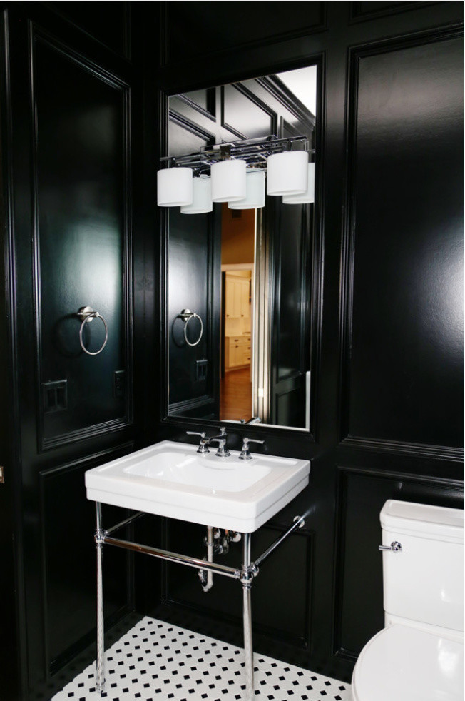 Inredning av ett klassiskt litet badrum, med svarta väggar, ett piedestal handfat, svart och vit kakel, en toalettstol med separat cisternkåpa och vinylgolv