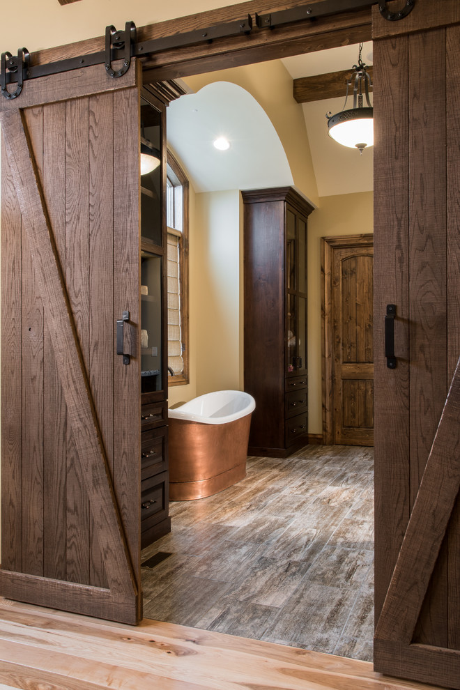 Пример оригинального дизайна: ванная комната в стиле рустика с фасадами в стиле шейкер, отдельно стоящей ванной, разноцветной плиткой и каменной плиткой