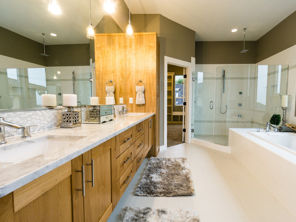 Exemple d'une grande salle de bain principale chic en bois clair avec un placard avec porte à panneau encastré, une baignoire posée, une douche d'angle, un carrelage blanc, un mur beige, un sol en carrelage de porcelaine, un lavabo encastré et un plan de toilette en marbre.