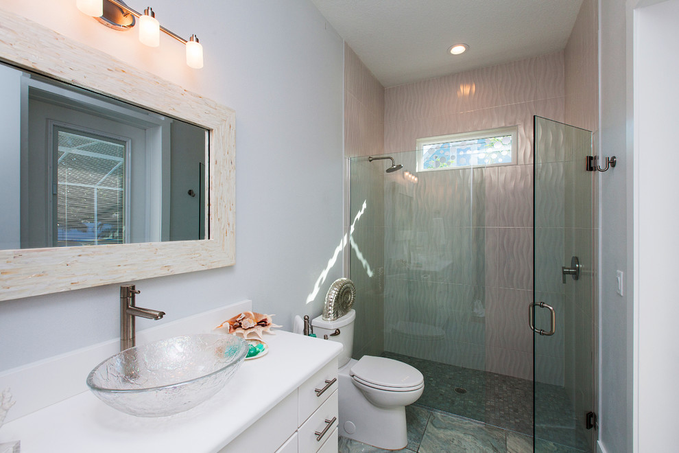 Exempel på ett modernt badrum, med ett fristående handfat, släta luckor, vita skåp, bänkskiva i kvarts, en toalettstol med hel cisternkåpa, vit kakel, glaskakel, vita väggar och klinkergolv i porslin