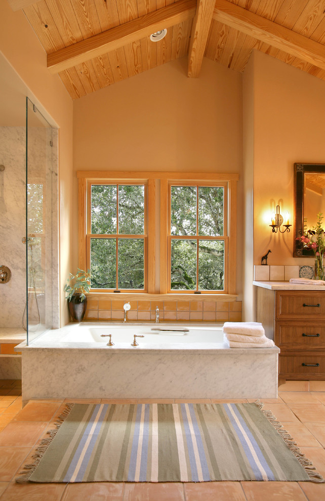 Klassisches Badezimmer mit Schrankfronten mit vertiefter Füllung, hellbraunen Holzschränken, Unterbauwanne, bodengleicher Dusche und beigen Fliesen in Sonstige