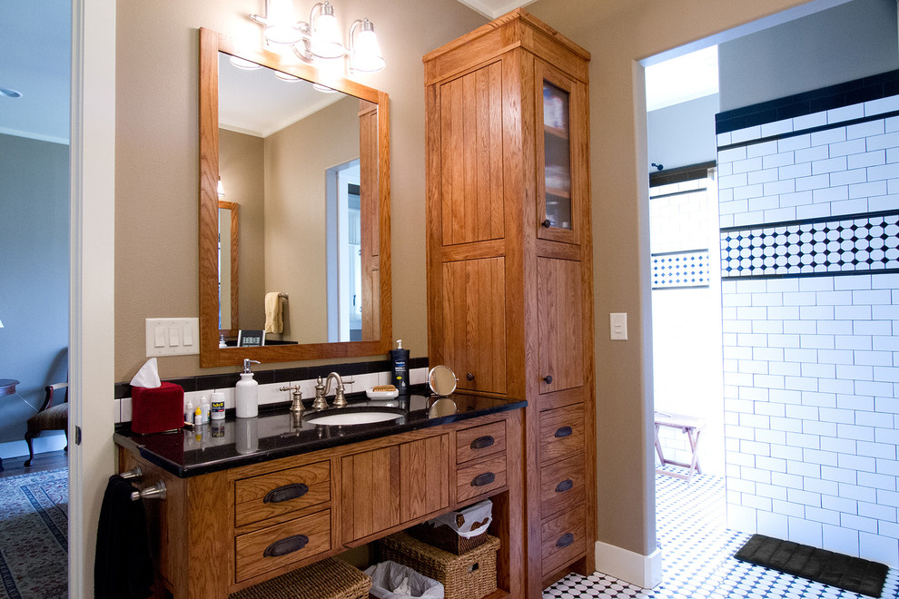 Inspiration for a large craftsman master multicolored tile and ceramic tile ceramic tile doorless shower remodel in Dallas with a drop-in sink, flat-panel cabinets, medium tone wood cabinets, granite countertops, a two-piece toilet and beige walls