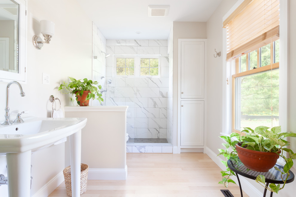 Mid-sized elegant 3/4 white tile and stone tile light wood floor alcove shower photo in Boston with shaker cabinets, white cabinets, a one-piece toilet, beige walls, a pedestal sink and a hinged shower door