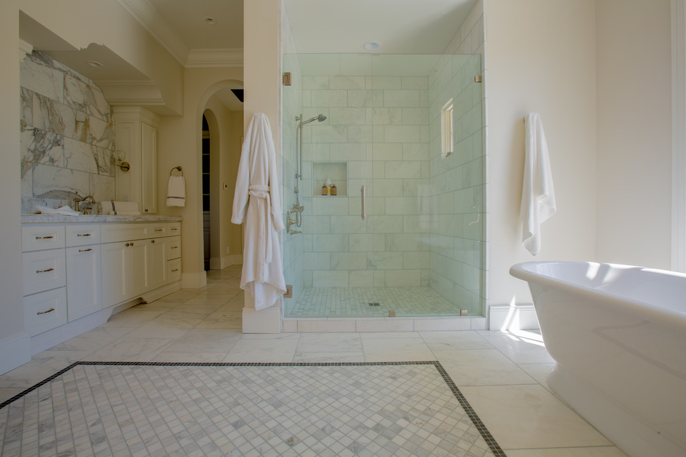 Klassisches Badezimmer mit weißen Schränken, freistehender Badewanne, Duschnische, Porzellanfliesen, beiger Wandfarbe und Mosaik-Bodenfliesen in Phoenix