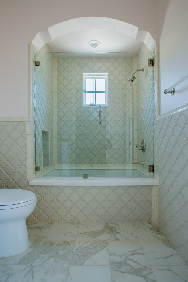 Idées déco pour une salle de bain classique avec des portes de placard blanches, un combiné douche/baignoire, WC à poser, des carreaux de porcelaine, un mur blanc et un sol en carrelage de porcelaine.
