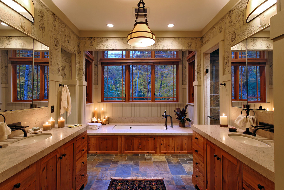 Aménagement d'une salle de bain principale montagne en bois brun avec un lavabo encastré, un placard à porte shaker, une baignoire encastrée, un mur multicolore et un sol en ardoise.